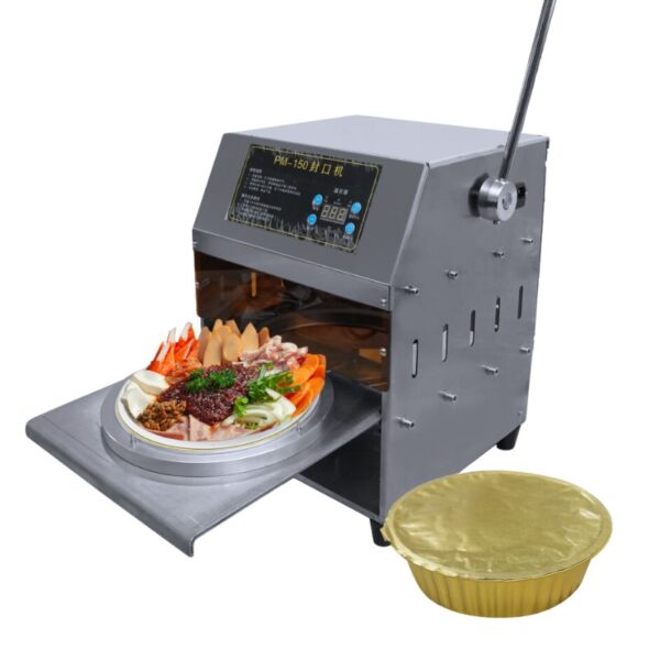 A Round Shape Lunch Box Semi-Auto Sealing Machine with an open tray displaying various ingredients, positioned next to a sealed golden lid.