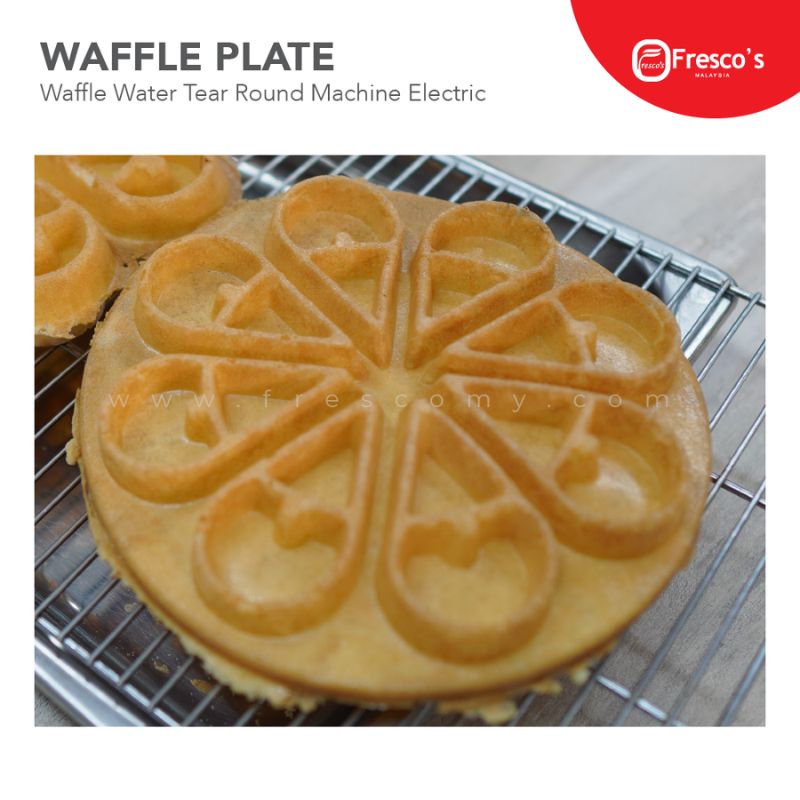 A waffle made with the Waffle Plate Water Tear Round Plate Mould Spare Part, featuring tear-shaped segments, is placed on a cooling rack.