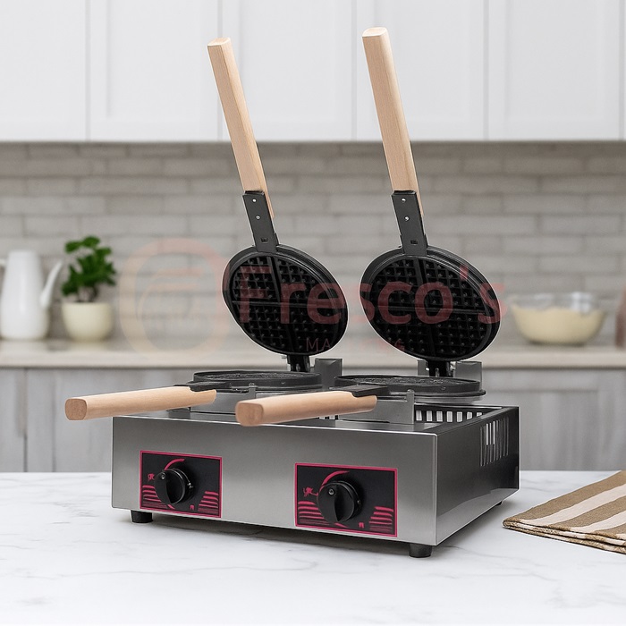A double waffle machine with open round plates and wooden handles sits on a marble countertop in a modern kitchen setting.