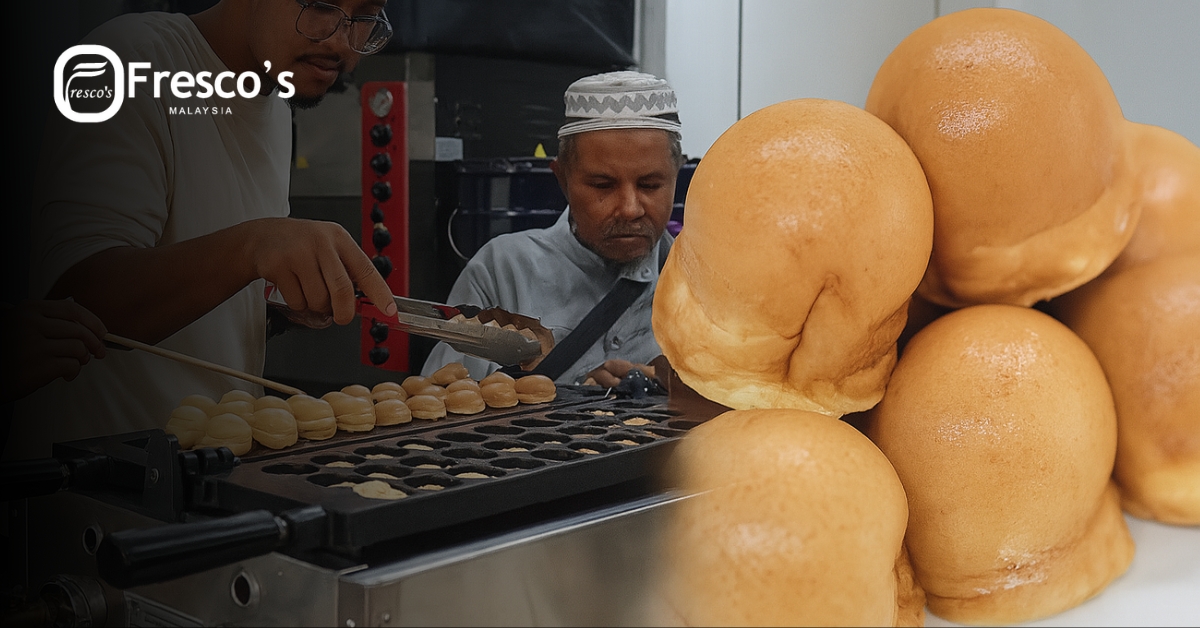 Two men prepare round pastries on a kayaball machine griddle, with a close-up of baked pastries stacked on the right. Fresco's Malaysia branding is visible in the corner.