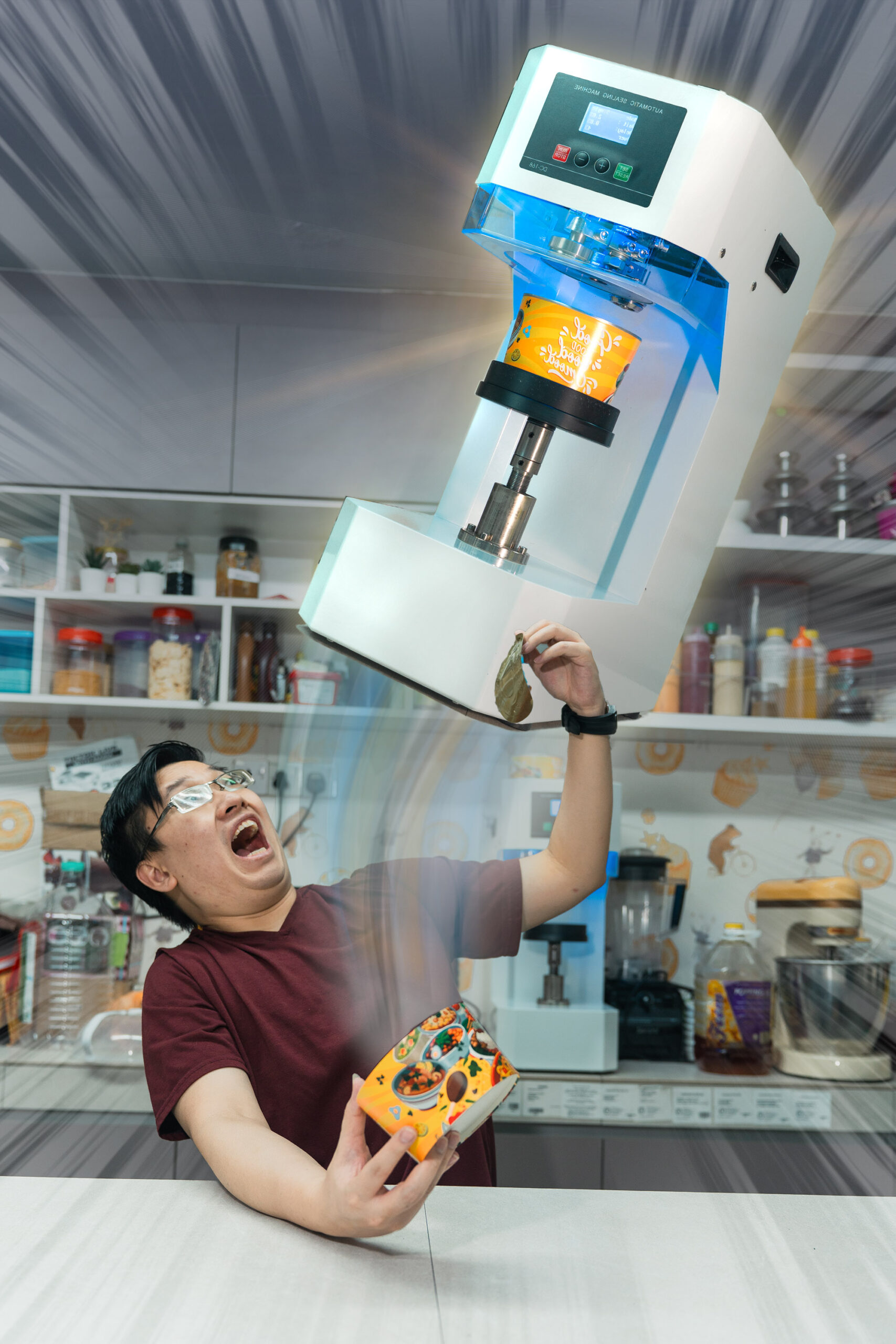A man in a kitchen appears startled as a can sealing machine hovers above and seals a cup he is holding, with motion effects emphasizing the action.