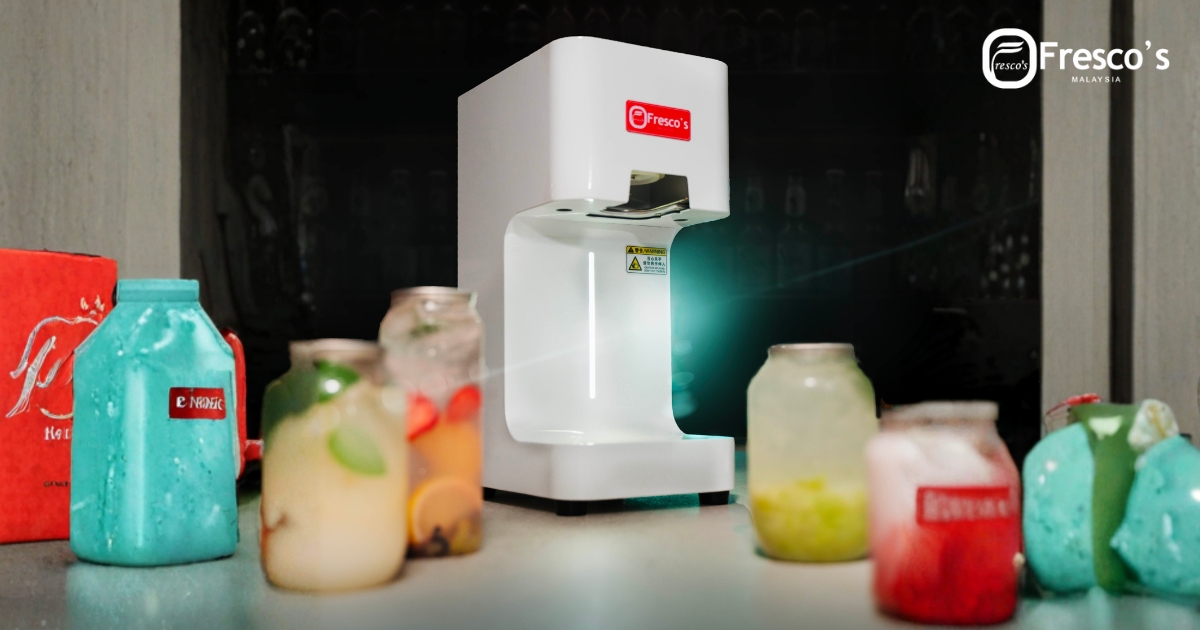 A white Fresco’s beverage machine sits on a counter beside a Professional Croffle Maker, surrounded by colorful drinks in glass jars.